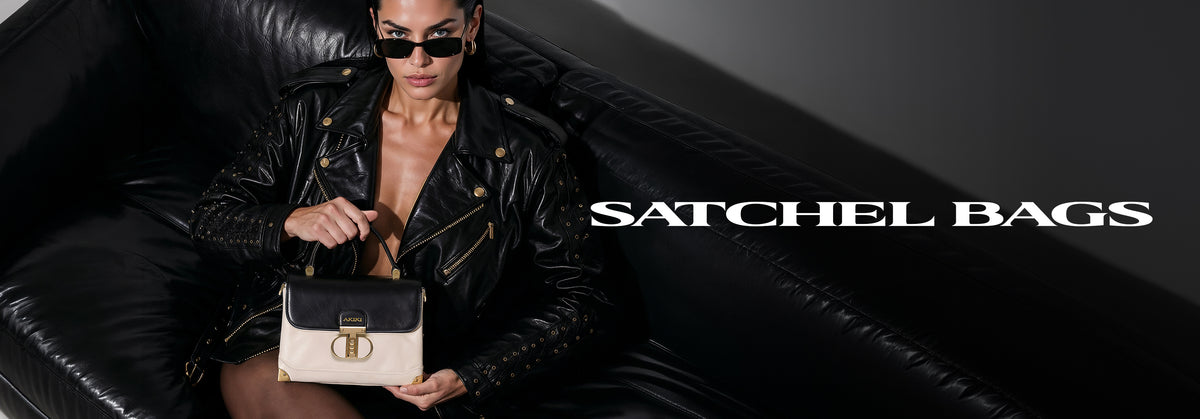 A woman in a black leather jacket and sunglasses sits on a black leather couch holding a black and beige Satchel bag with gold hardware. The text 'SATCHEL BAGS' is displayed on the right side of the image.